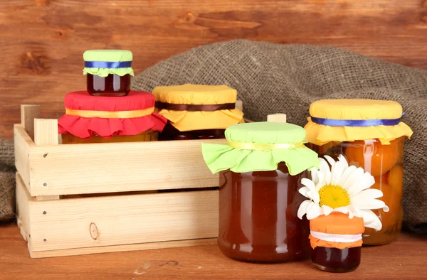 Frascos con fruta enlatada sobre fondo de madera —  Fotos de Stock