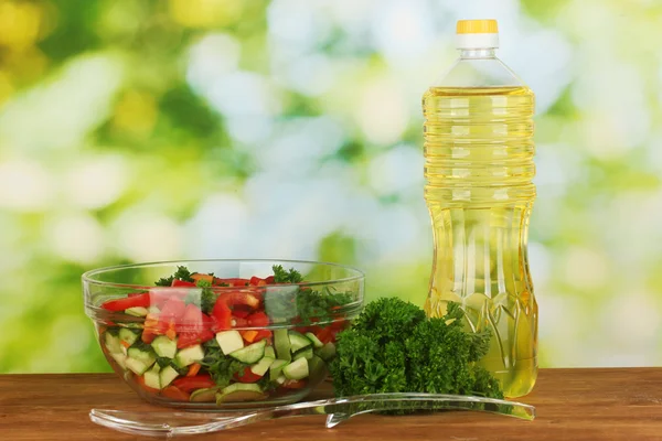 Fresh salad and oil on green background — Stock Photo, Image