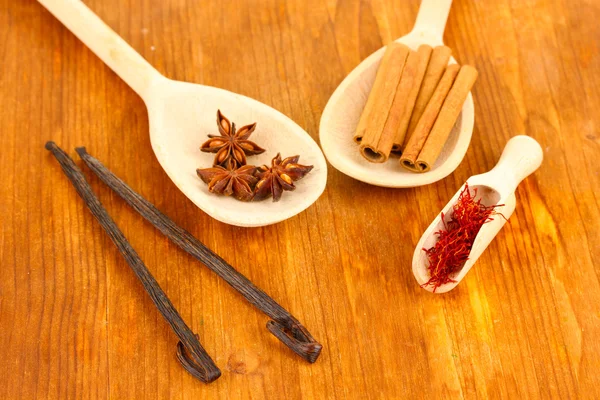 Temperos perfumados em colheres de madeira em um fundo de madeira close-up — Fotografia de Stock