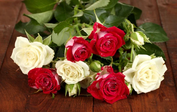 Όμορφα τριαντάφυλλα σε κοντινό πλάνο ξύλινο, παρασκήνιο — Φωτογραφία Αρχείου