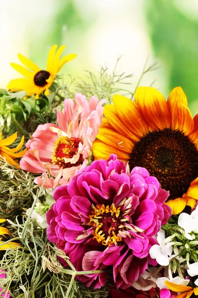 Beautiful bouquet of bright flowers close-up on wooden table on nature back — Stock Photo, Image