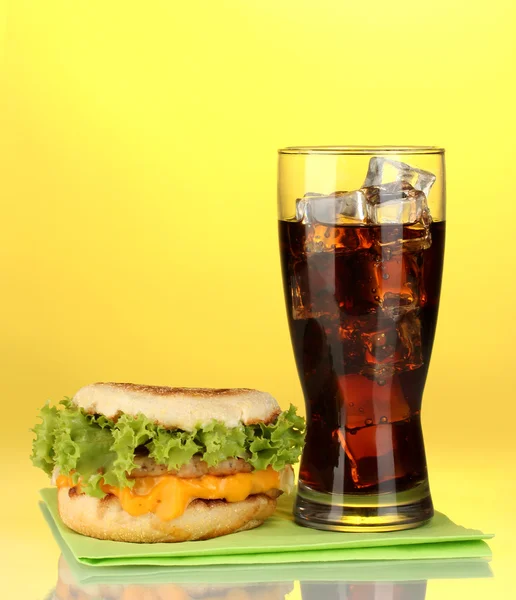 Gustoso panino e bicchiere con cola, su fondo giallo — Foto Stock