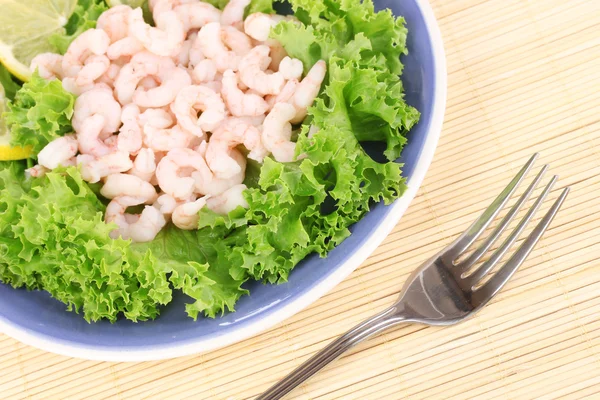 Deliciosos camarones marinados en plato sobre estera de bambú —  Fotos de Stock