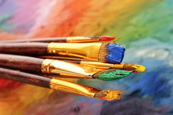 Akrilik boya ve ahşap palet üzerinde fırçalar — Stok fotoğraf