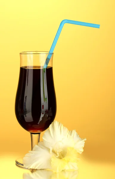 Bicchiere con cocktail e bocciolo di gladiolo su sfondo giallo primo piano — Foto Stock