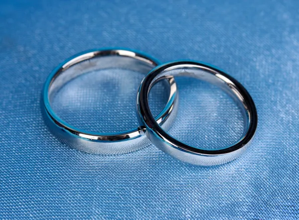 Обручальные кольца на атласной подушке крупным планом — стоковое фото