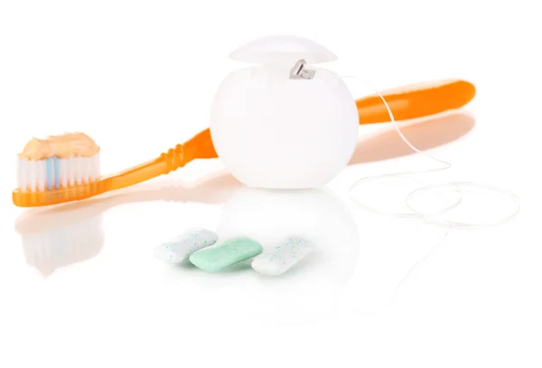 Escova de dentes, goma de mascar e fio dental isolado em branco — Fotografia de Stock