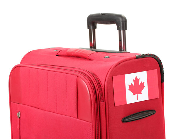 red suitcase with sticker with flag of Canada isolated on white