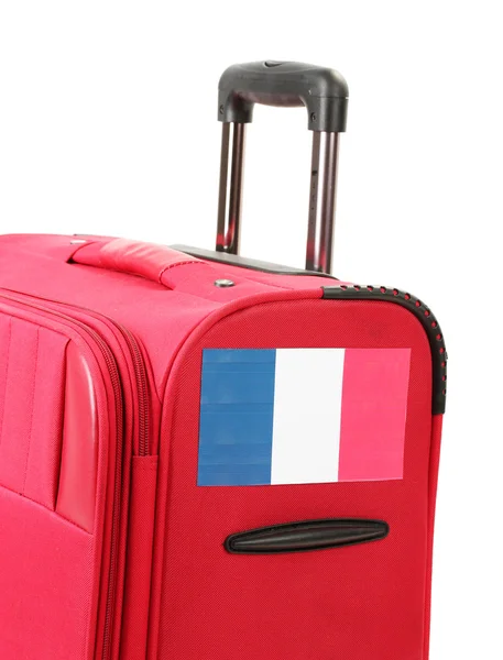Red suitcase with sticker with flag of France isolated on white — Stock Photo, Image