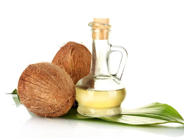 Decanter with coconut oil and coconuts isolated on white — Stock Photo, Image