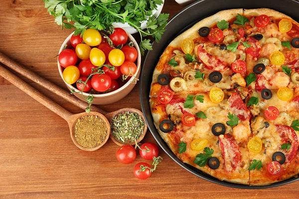 Composición colorida de deliciosa pizza, verduras y especias en ba de madera — Foto de Stock