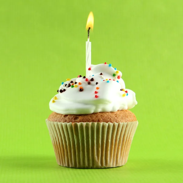 Cupcake de aniversário saboroso com vela, no fundo verde — Fotografia de Stock