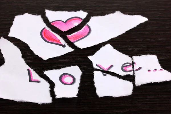 Gescheurd papier met woorden love close-up op houten tafel — Stockfoto