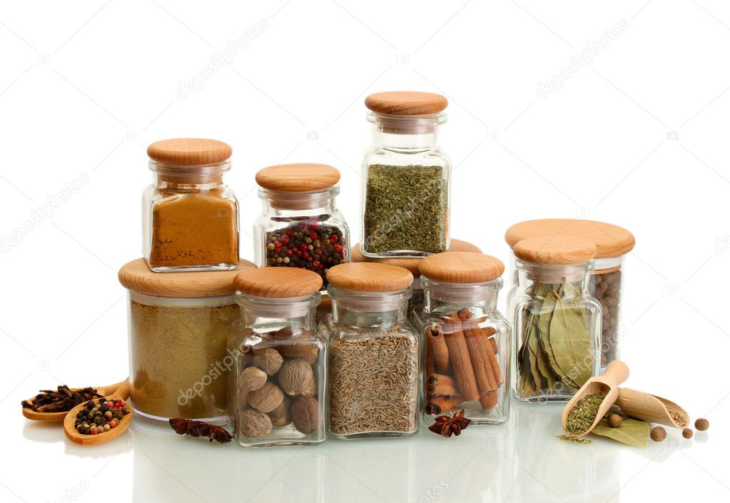 jars and wooden spoons with spices isolated on white