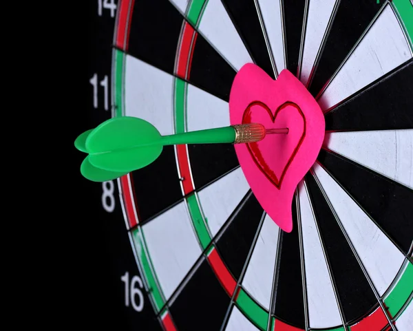 Darts with stickers depicting the life values close-up on black background — Stock Photo, Image