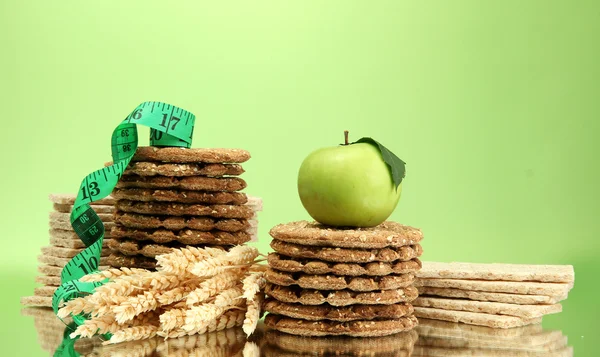 Sabroso pan crujiente, manzana y cinta métrica, sobre fondo verde — Foto de Stock