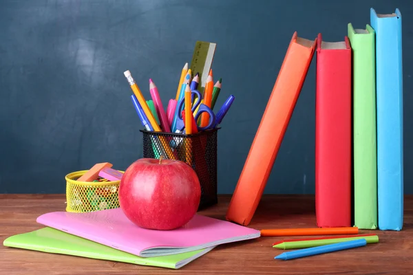 Skład książki, artykuły papiernicze i jabłko na biurku nauczyciela w — Zdjęcie stockowe