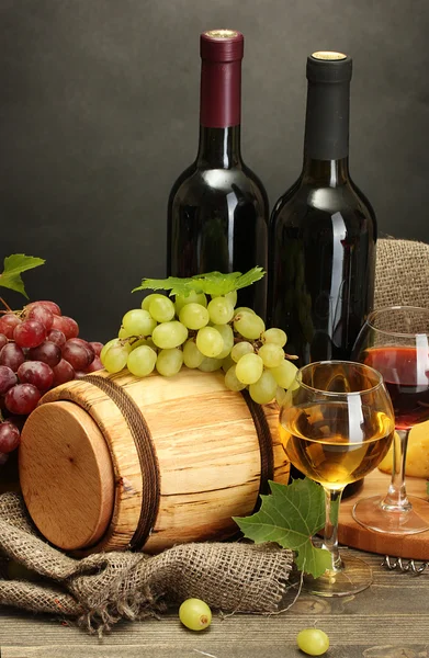 Fat, flaskor och glas vin, ost och mogna druvor på träbord — Stockfoto