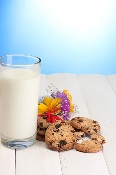 Vaso de leche, galletas de chispas de chocolate con cinta roja y flores silvestres en w —  Fotos de Stock