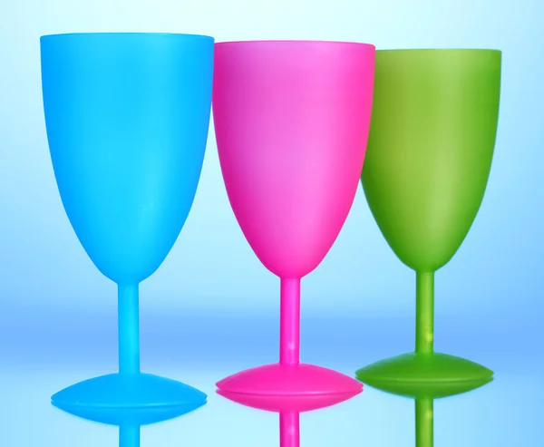 Světlé plastových pohárů na modrém pozadí — Stock fotografie