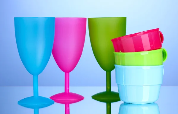 Bright plastic tableware on blue background — Stock Photo, Image