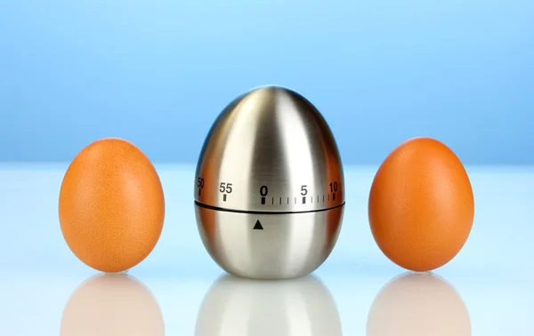 Eieruhr und Ei auf blauem Hintergrund — Stockfoto