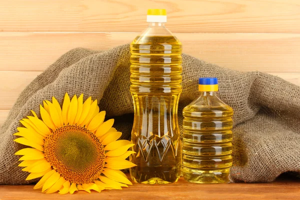 Sunflower oil and sunflower on wood background — Stock Photo, Image