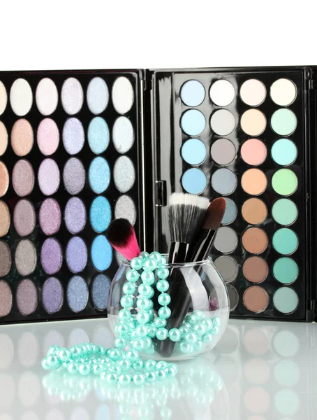 Maquillaje cepillos en un tazón con collar de perlas en la paleta de sombras backgro —  Fotos de Stock