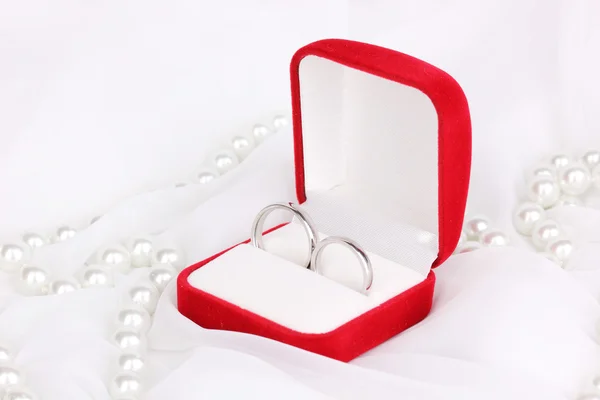 结婚戒指上白色的布背景的红色框中 图库图片