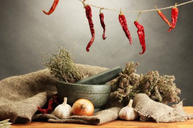 harç ve sebzeler, gri arka plan üzerinde ahşap masa üzerinde kurumuş otlar