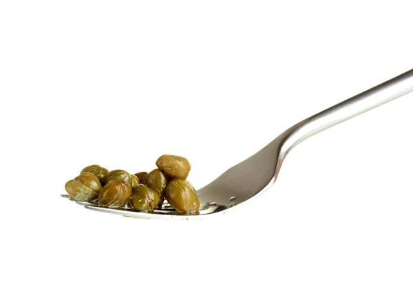 Green capers in metal fork on white background close-up — Stock Photo, Image