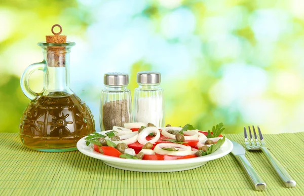 Salada com alcaparras na placa em fundo verde brilhante — Fotografia de Stock