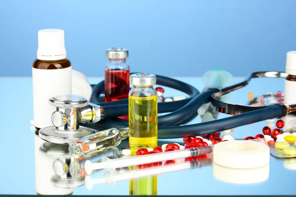 Medicines and a stethoscope on a blue background close-up — Stock Photo, Image