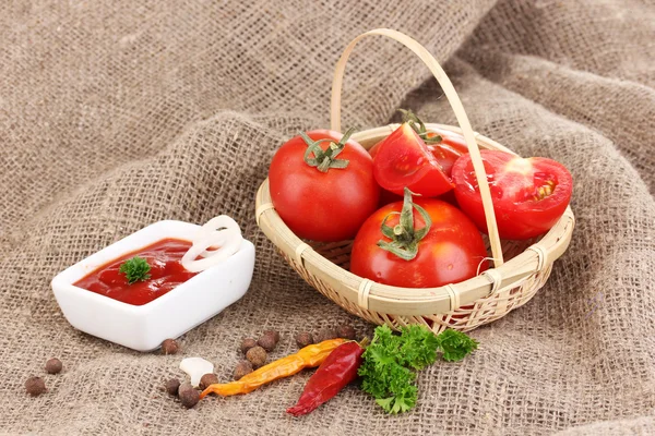 Ketchup and ripe tomatoes on sacking close-up — Stock Photo, Image