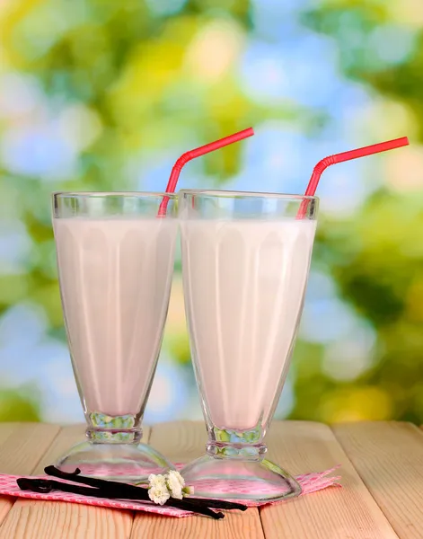 Vanilla milk shakes on wooden table on bright background — Stock Photo, Image