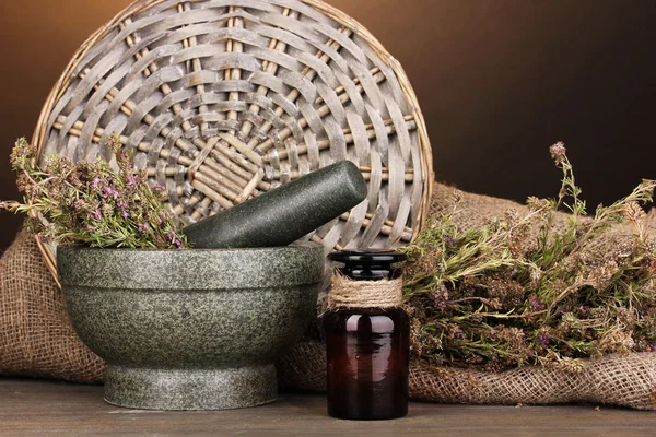 Thyme herb and mortar on wooden table on brown background — Stock Photo, Image