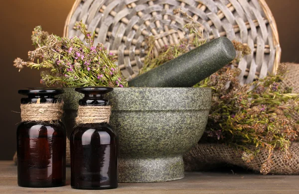 Thyme herb and mortar on wooden table on brown background — Stock Photo, Image