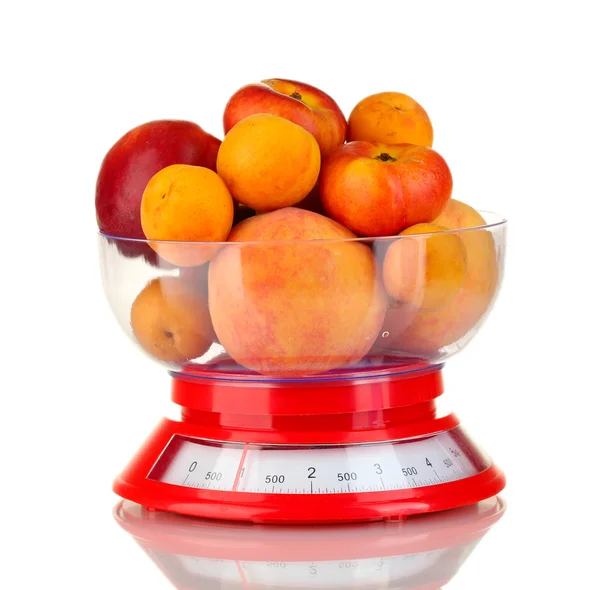 Спелые фрукты в кухонных весах изолированы на белом — стоковое фото