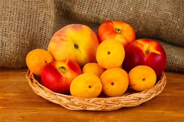 Maturare frutta su stuoia di vimini su sfondo tela primo piano — Foto Stock