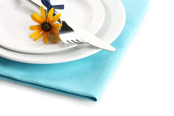 Нож, вилка и цветок на тарелке, изолированные на белом — стоковое фото