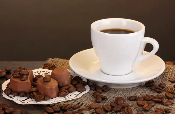 Xícara de café na mesa de madeira no fundo marrom — Fotografia de Stock