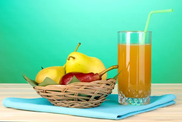 Pear juice with pears on wooden table on blue background