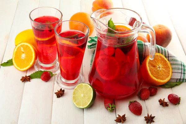 Sangría en frasco y vasos con frutas, sobre mesa de madera blanca — Foto de Stock