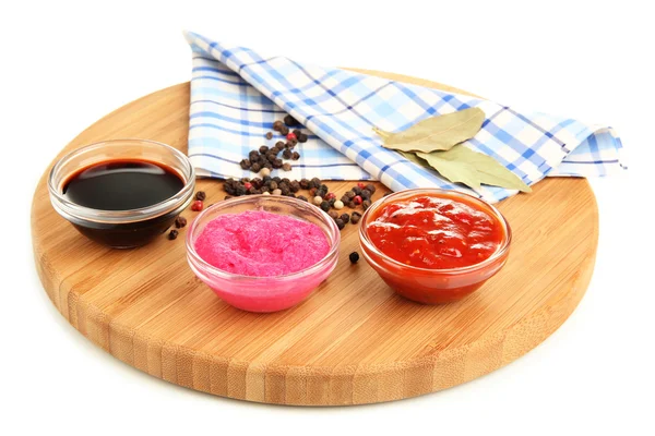 Various sauces on chopping board isolated on white — Stock Photo, Image