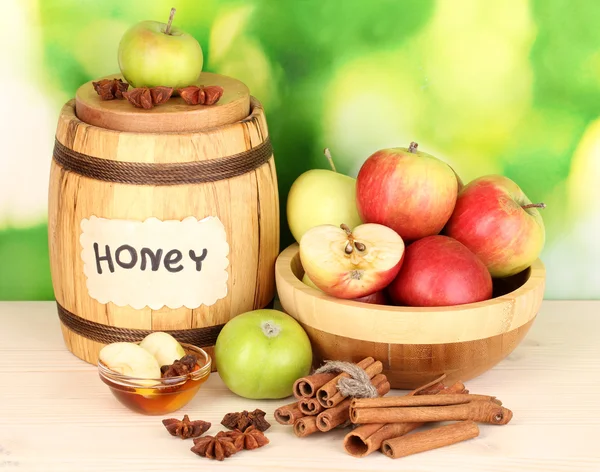 Honey and apples with cinnamon on wooden table on natural background — Stock Photo, Image