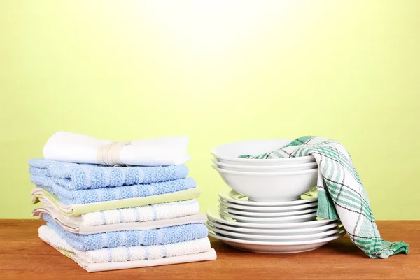 Кухонные полотенца с посудой на зеленом фоне крупным планом — стоковое фото