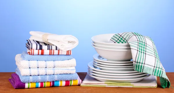 ผ้าเช็ดตัวในครัวพร้อมจานบนพื้นหลังสีฟ้า — ภาพถ่ายสต็อก