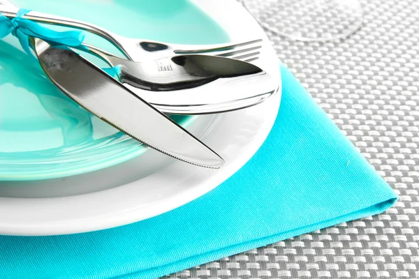 Assiettes vides bleues avec fourchette, cuillère et couteau sur une nappe grise — Photo