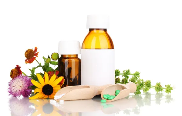 Tabletler ve üzerinde beyaz izole çiçeklerle ilaç şişeleri — Stok fotoğraf