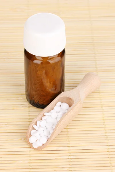 Flacon de médicament avec comprimés sur tapis de bambou — Photo